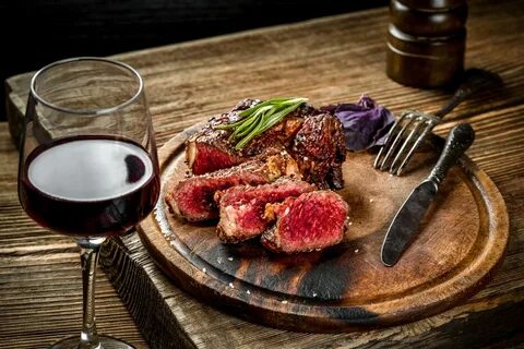 Steak with red wine on a table.