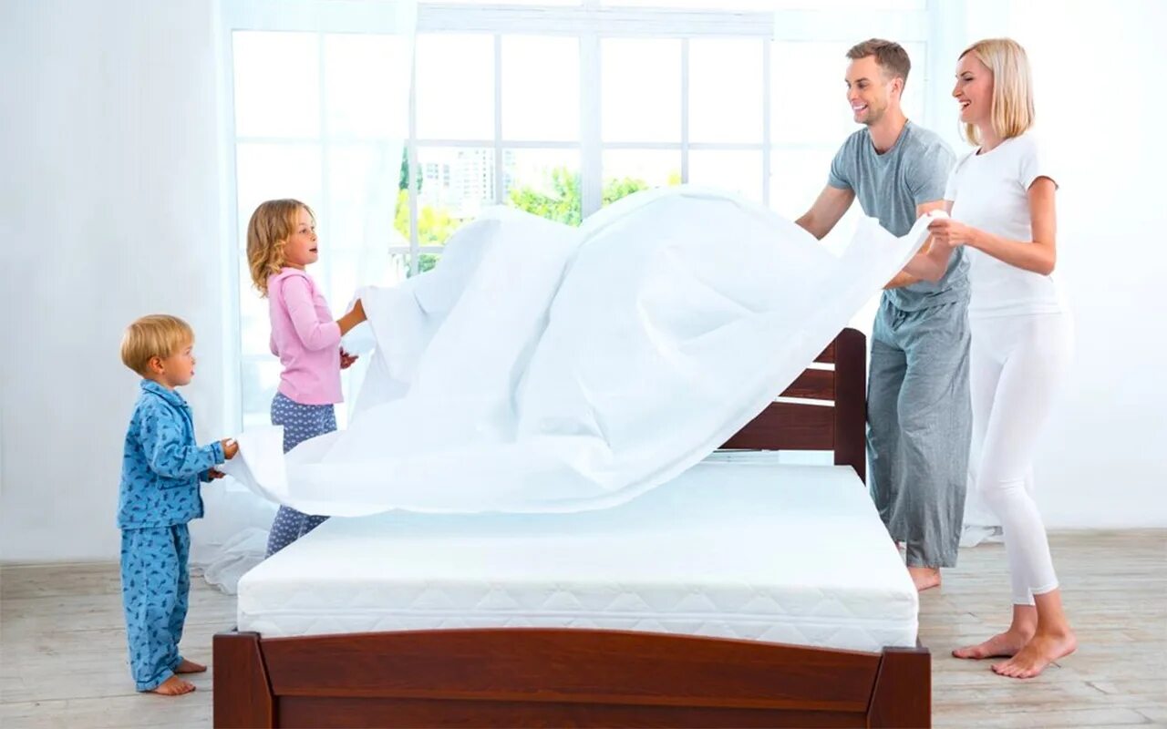 Заправленная кровать. Кровать для всей семьи. Семья в постели. Застеленная кровать.