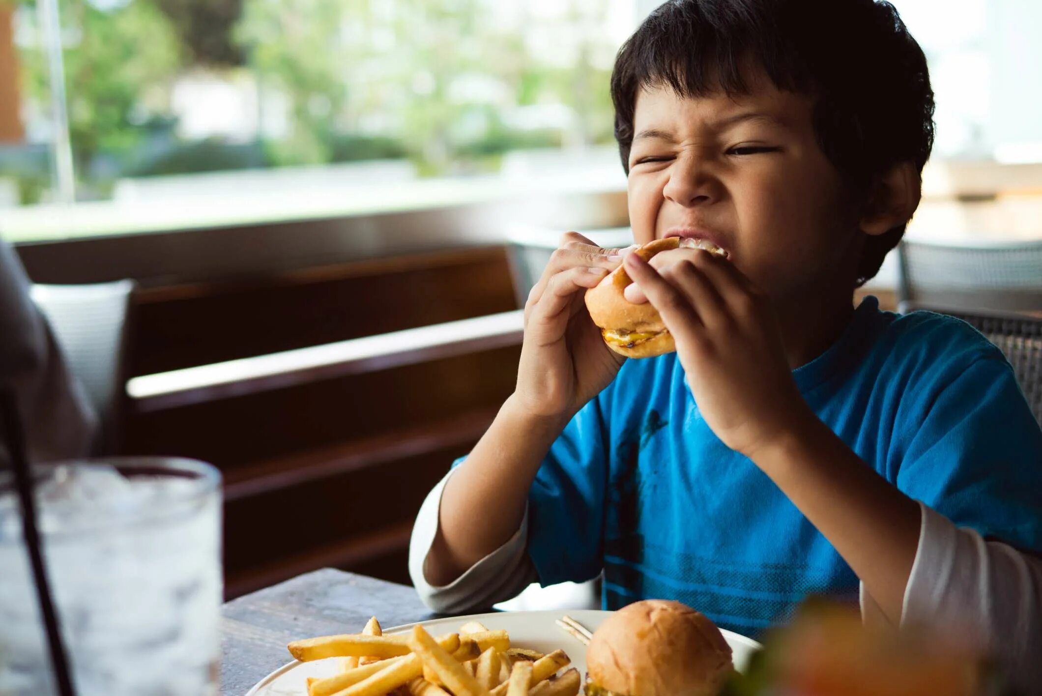 Еда для детей. Мальчик ест фаст фуд. Неправильное питание детей. Ребенок с фастфудом.