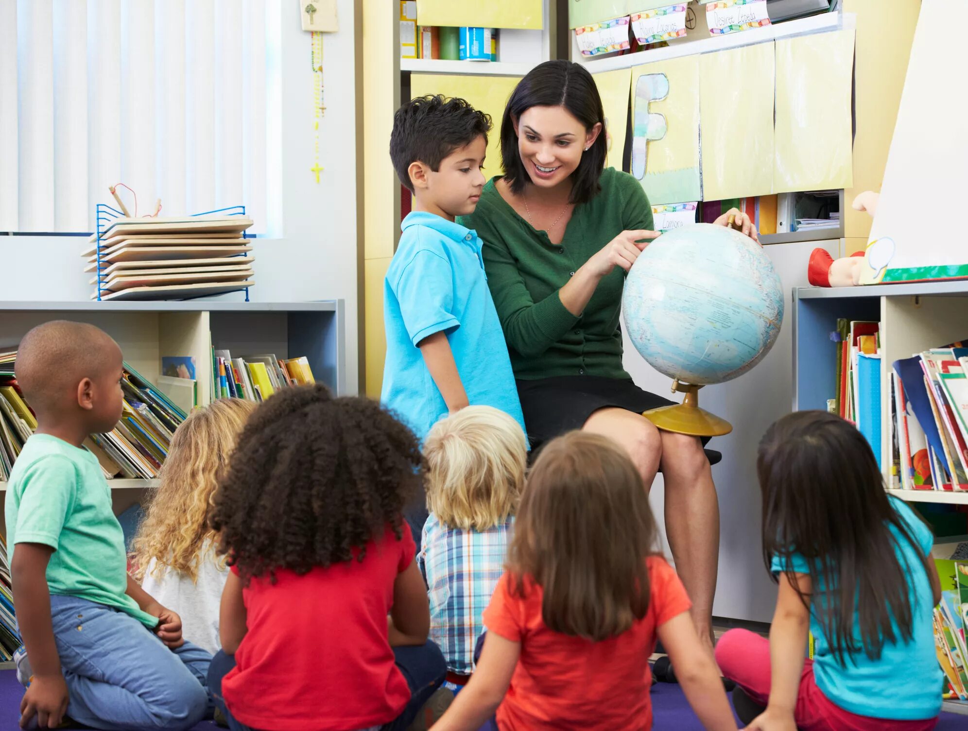 Учитель и дети с глобусом. Глобус для детей. Воспитатель с детьми с глобусом. Учитель показывает детям Глобус.