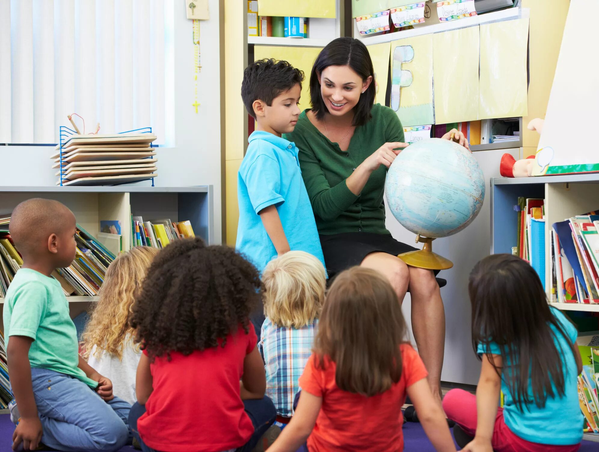 The teacher made the pupils. Учитель и дети с глобусом. Глобус для детей. Воспитатель с детьми с глобусом. Учитель показывает детям Глобус.