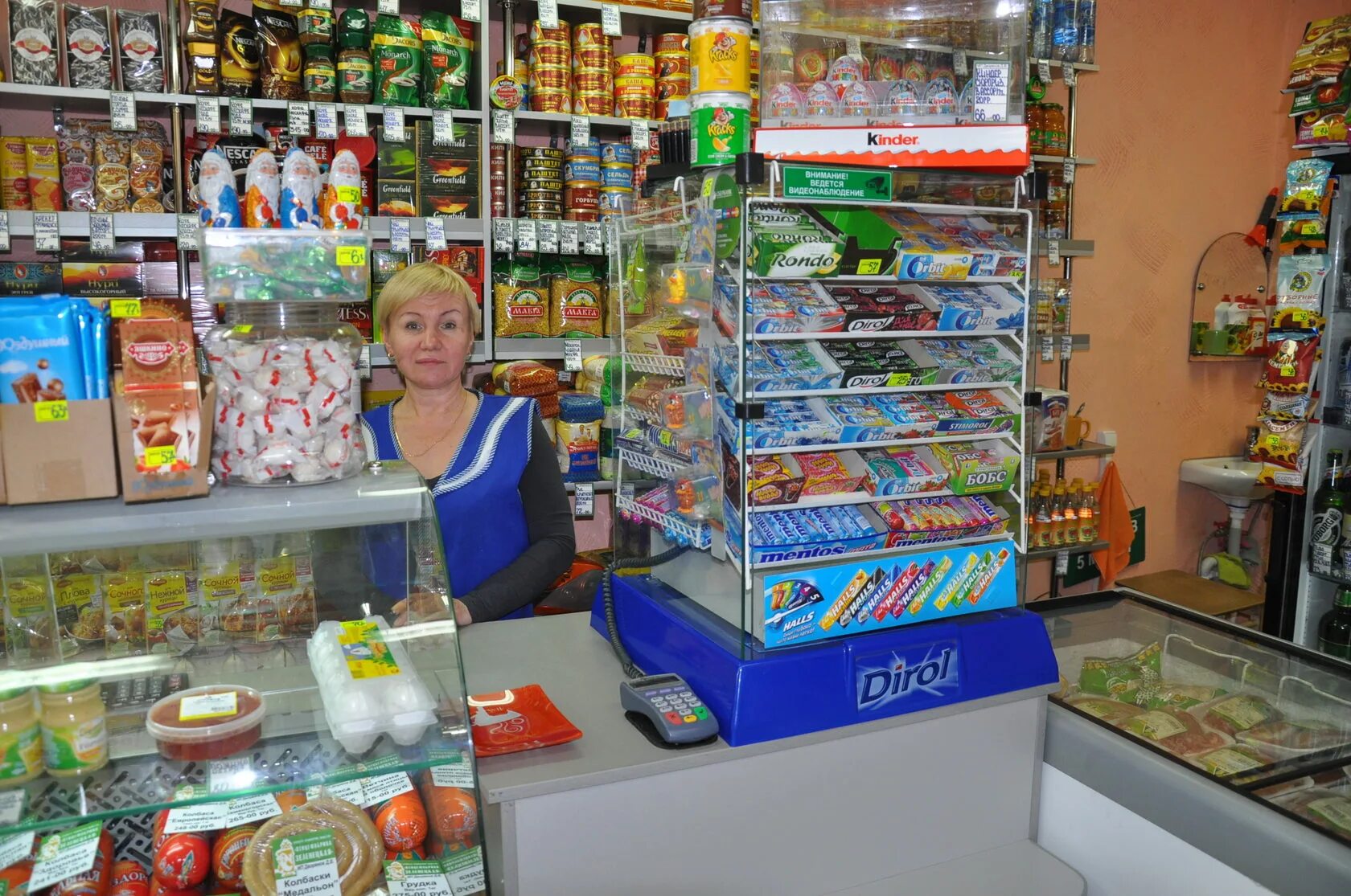 Выкладка товара в маленьком продуктовом магазине. Прилавок продуктового магазина. Выкладка в маленьком магазине. Выкладка товара в продуктовом магазине через прилавок.