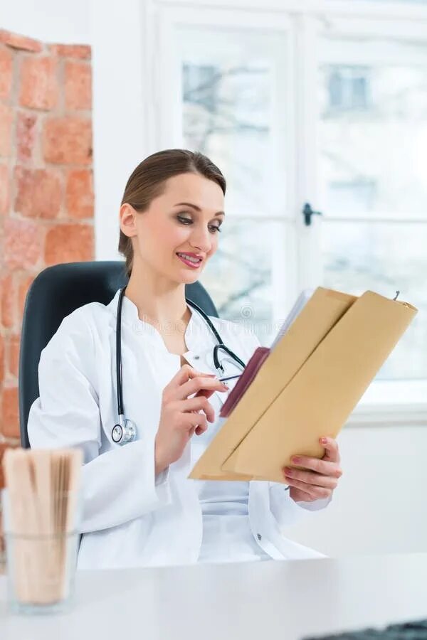 Читать врач и студентка. Медик с документами. Документы доктора. Девушка врач читает. Врач за столом в шапке.