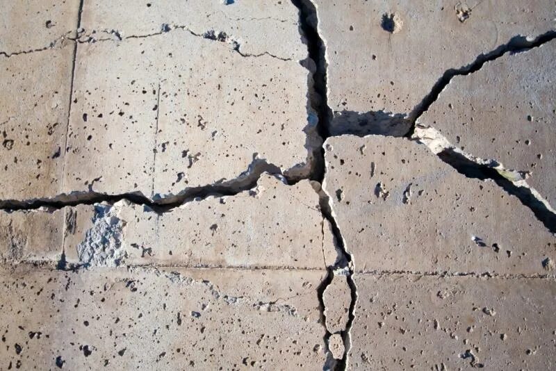 На стене появились трещины. Разрушение бетона. Трещины в бетоне. Микротрещины в бетоне. Трещины в железобетоне.