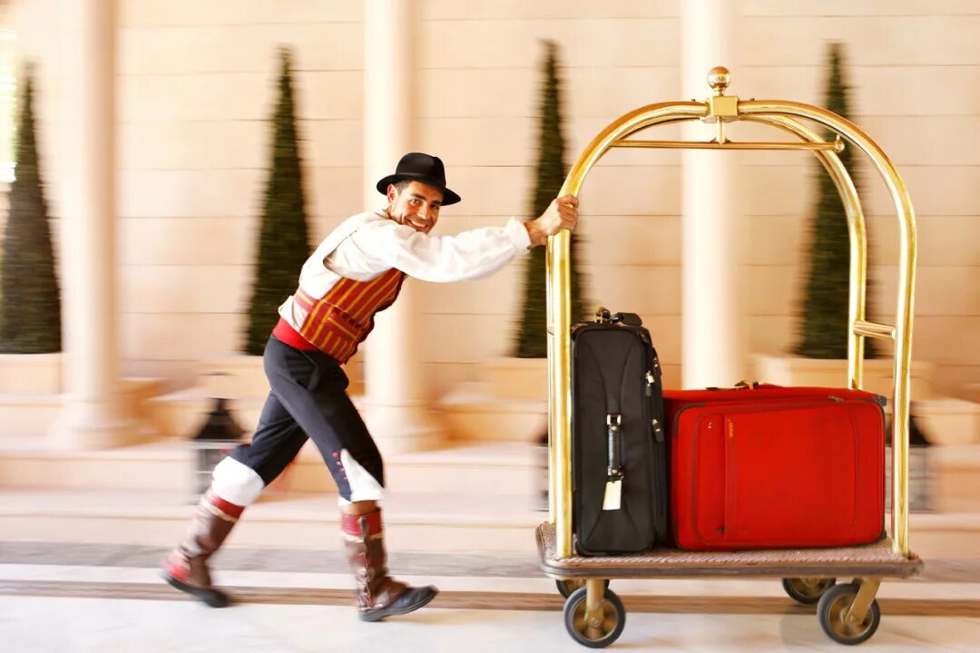 Как называется носильщик. Bellboy в гостинице. носильщик багажа в гостинице. носильщик в отеле. подносчик багажа в отеле.