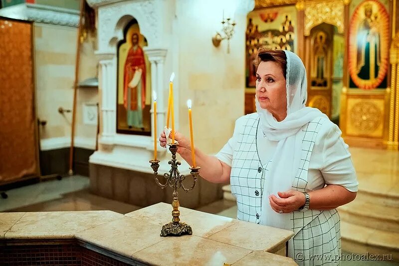 В церковь принято ходить. Женщина в храме. церковь дама. девушка крестится в храме. дама в храме.