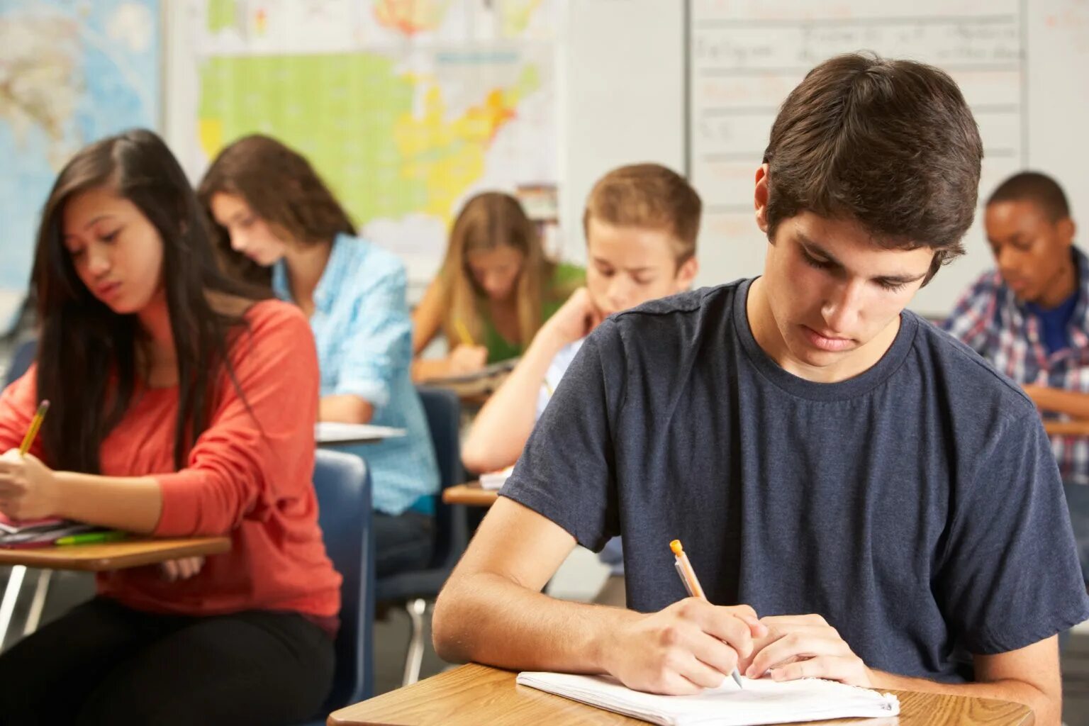 The teacher made the pupils. Подростки в школе. Студент за партой. Студенты на занятиях. Подростки на занятиях.