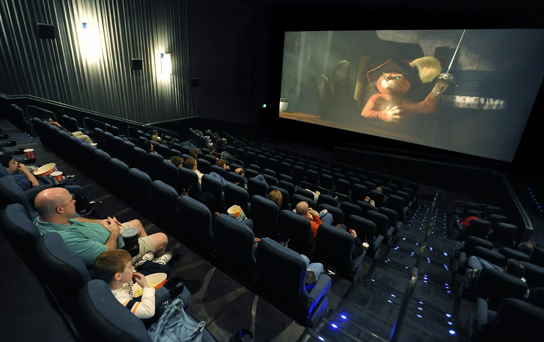 Дата кинотеатрах. Люди в кинотеатре. Экран кинотеатра с людьми. Зал кинотеатра с людьми. Кинотеатр зал с фильмом.