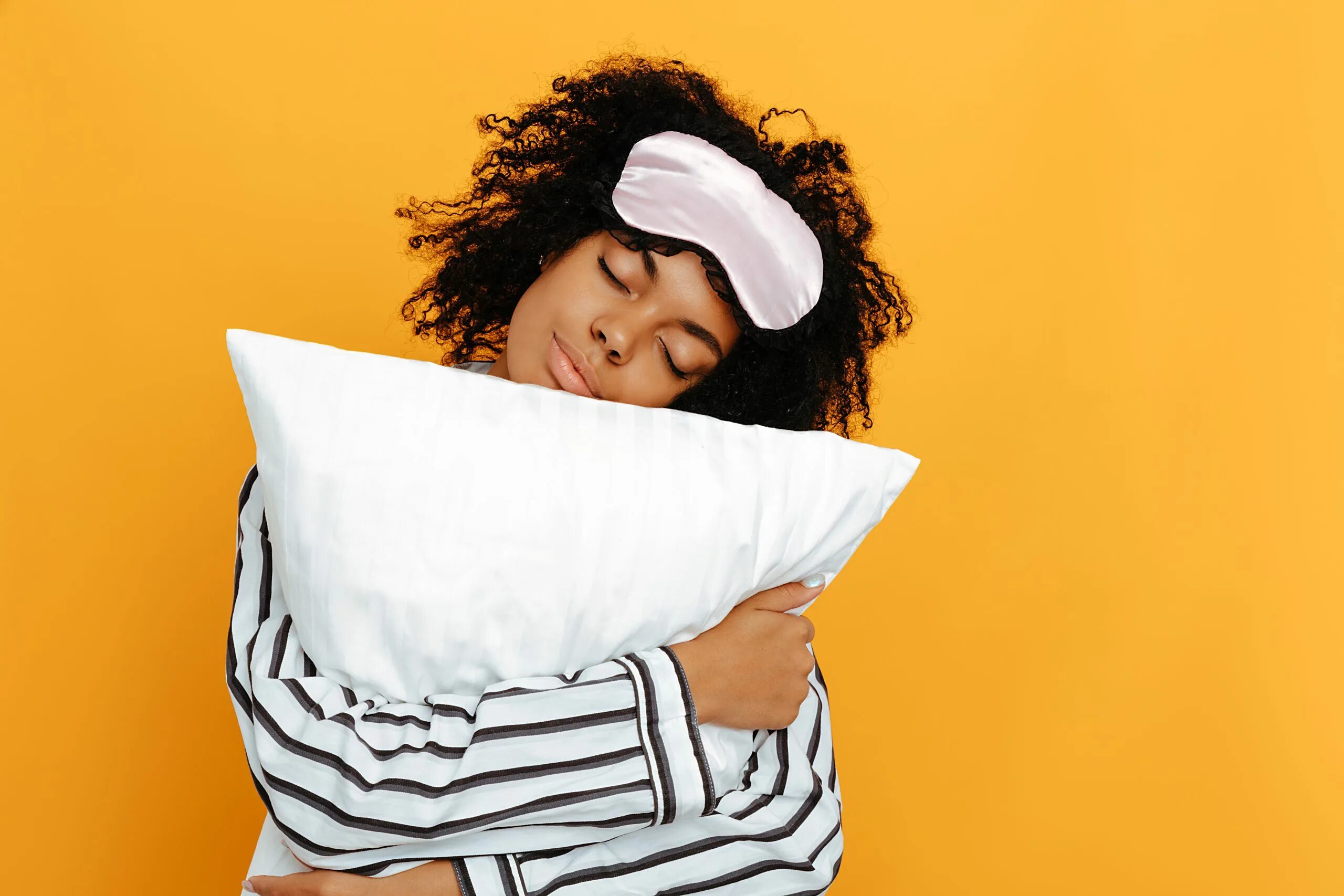 Sleep habits. Девушка обнимает подушку. Девушка в пижаме с подушкой. Сон стоковые фото.