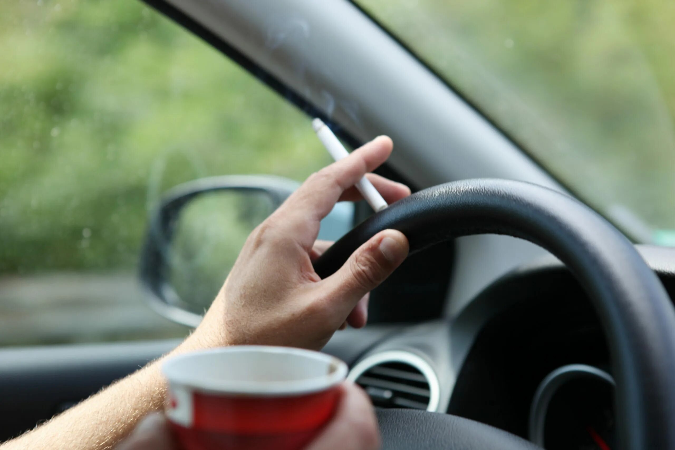 Еду в машине в руках. Кофе в машине за рулём. Рука сигарета руль. Кофе в руке в машине. Курит в машине.
