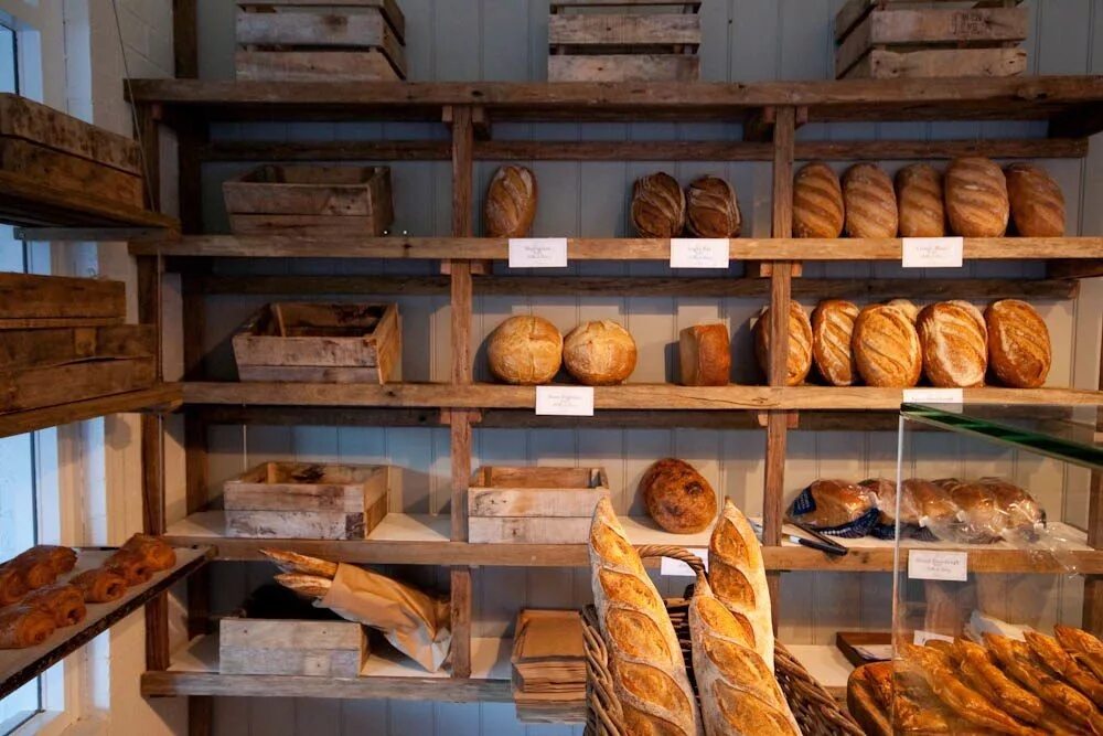 Деревня пекарня. Полки для хлеба в пекарне. Хлебобулочные изделия на прилавке. Хлебные полки пекарня. Хлебный прилавок.