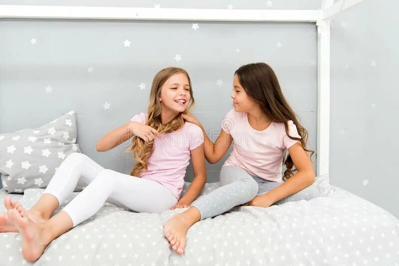 Сестренка отдыхает. Дети веселятся в спальне. Сестра в спальне. Дети в милых пижамах. Спальня для девочек-сестёр.