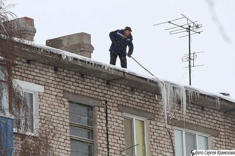 сбивание сосулек. приспособление для сбивания сосулек. сбивать сосульки. чистка крыш от снега и наледи. сбивают сосульки с крыш.