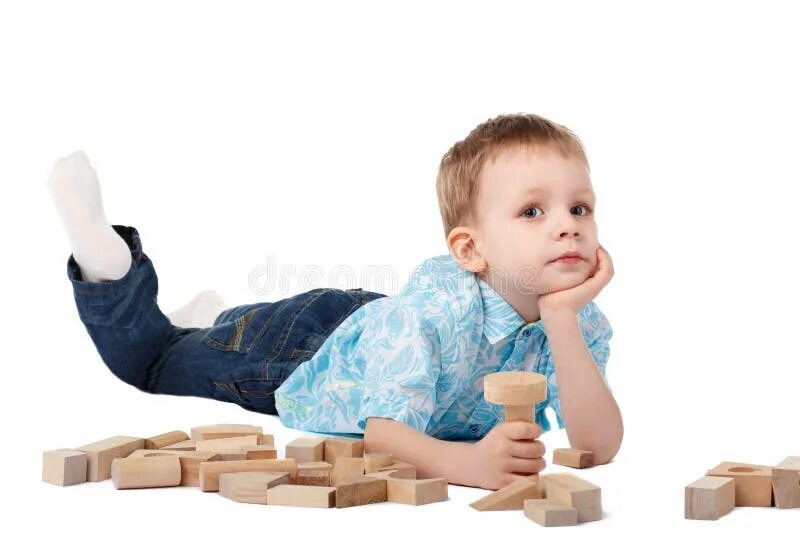 Build a boy. Мальчик играет на полу. ребенок играет с деревянным конструктором на полу. a little boy sitting on the floor plays with toy cars and holds one of them in his hands.