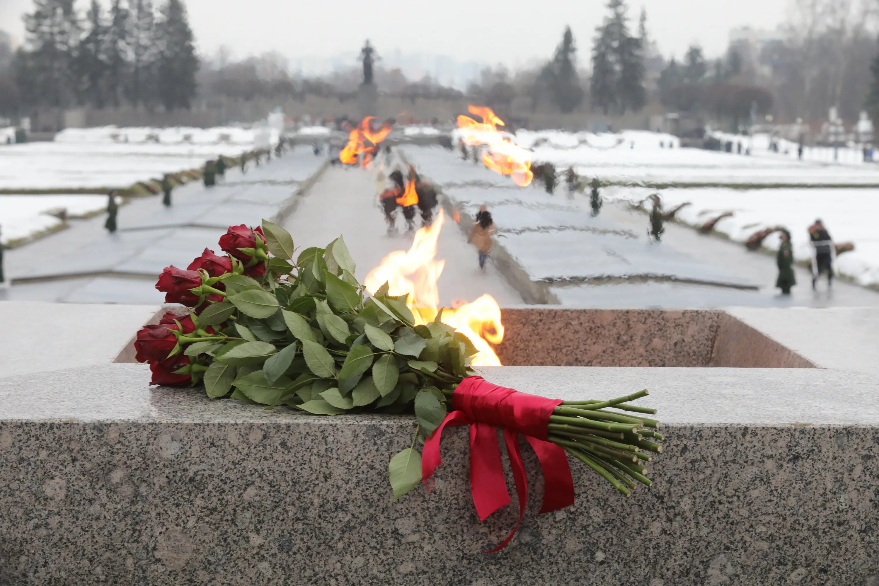 Как чтут память о прорыве блокады ленинграда. Вечный огонь на Пискаревском кладбище. Пискаревское кладбище блокада Ленинграда. Пискарёвское мемориальное кладбище огонь. Вечный огонь Ленинград Пискаревское кладбище.