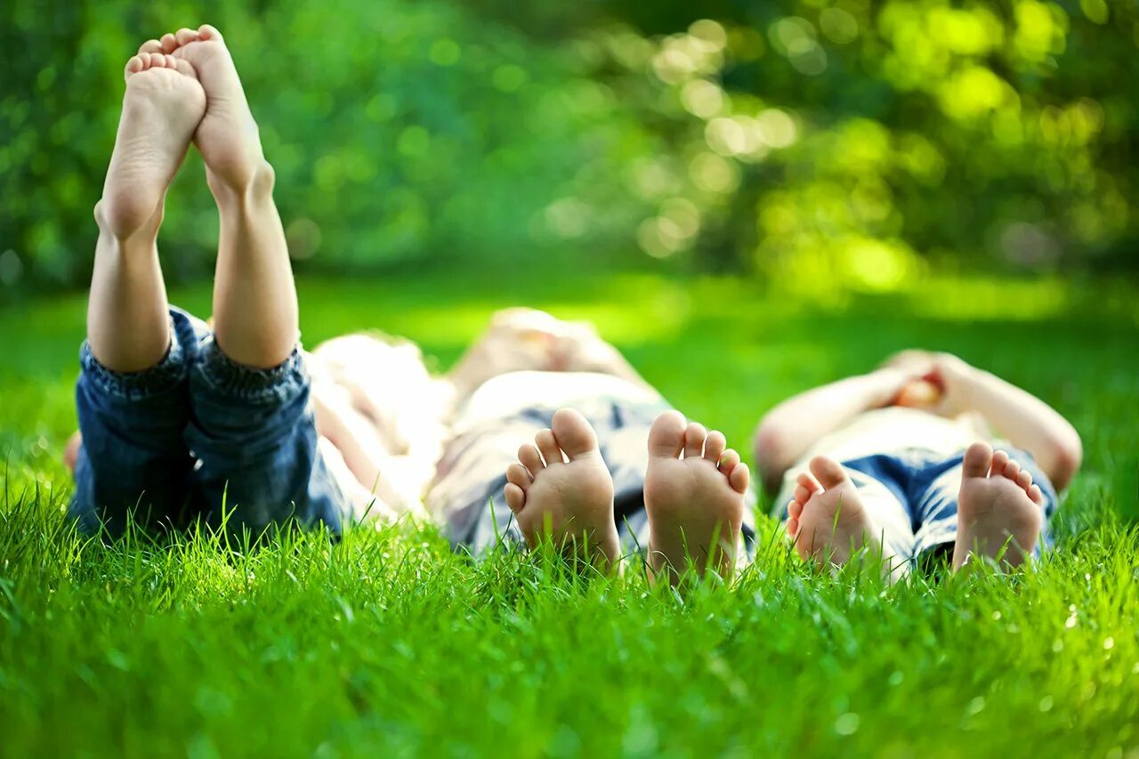 Лето дети. Лежит на траве. Дети и природа. Радостные люди на природе.