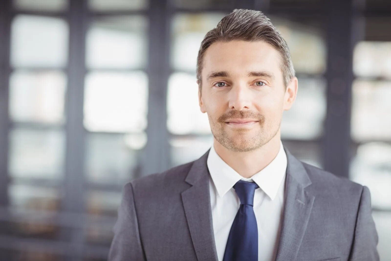 бизнесмен. портрет бизнесмена. мужчина в костюме за столом. портрет бизнесмена. деловой мужчина.