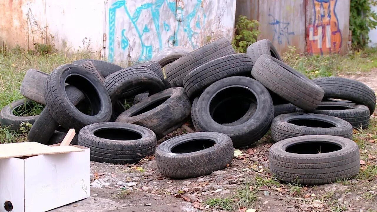 Старые покрышки. Свалки резиновых шин. Старая автомобильная покрышка. Покрышки в земле. Куда можно сдать шины