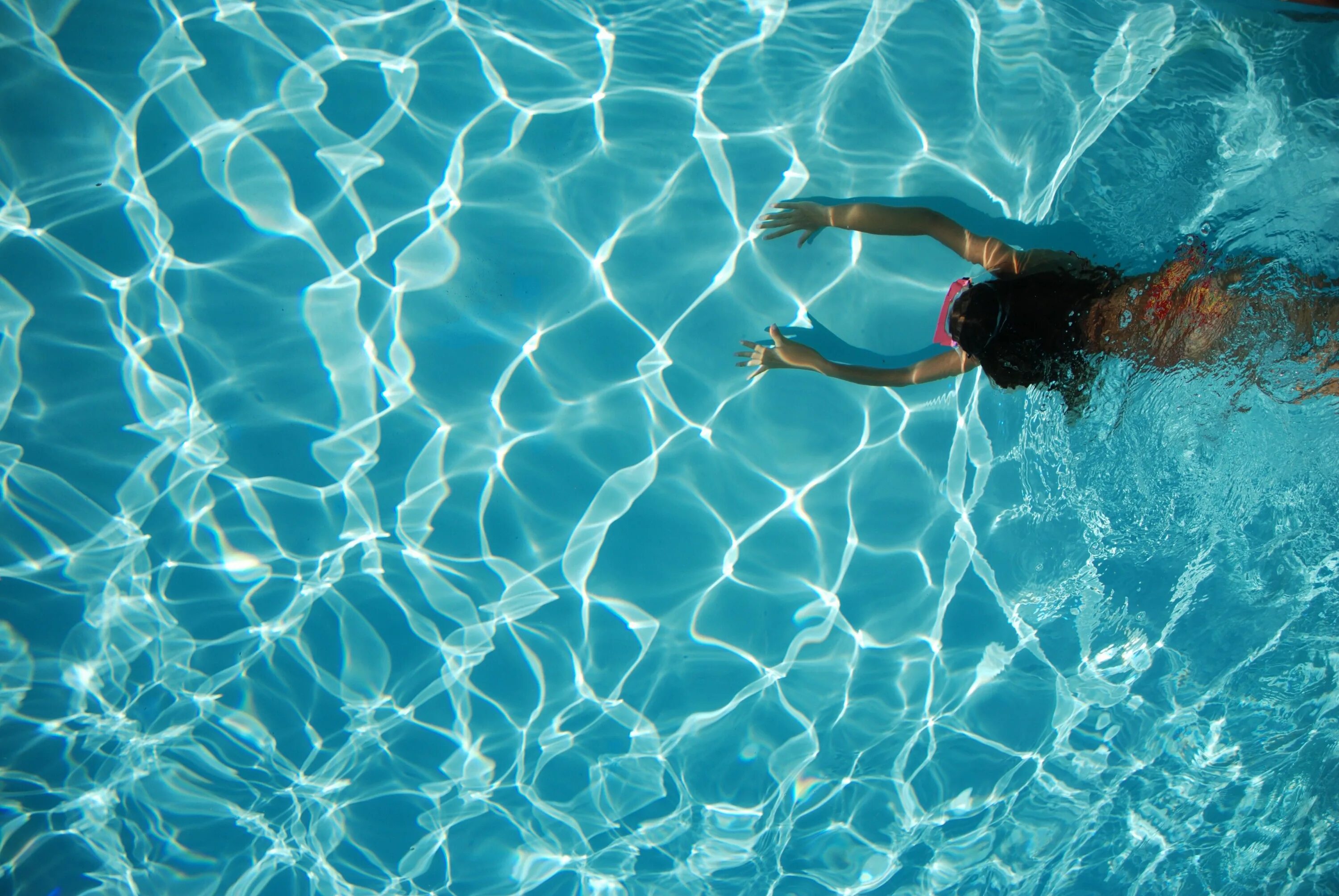 Вода в бассейне. Бассейн под водой. Прозрачная вода в бассейне. Девушка плавает.