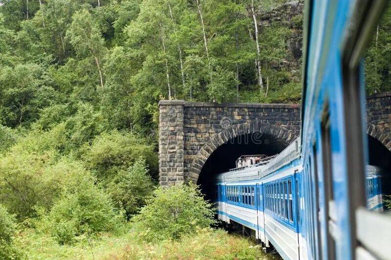Перед входом в тоннель пассажирского поезда. Паровоз Кругобайкальская железная дорога. Тоннель Кругобайкальской железной дороге. Поезд въезжает в тоннель. Поезд в пещере.