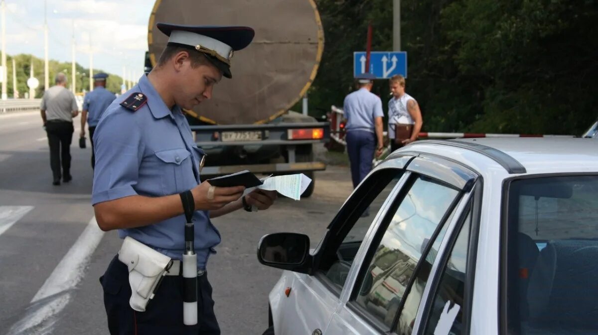 Административные правонарушения на автомобиле. Протокол инспектора ГИБДД. Полицейский штраф. Административное правонарушение. Полицейский заполняет протокол.