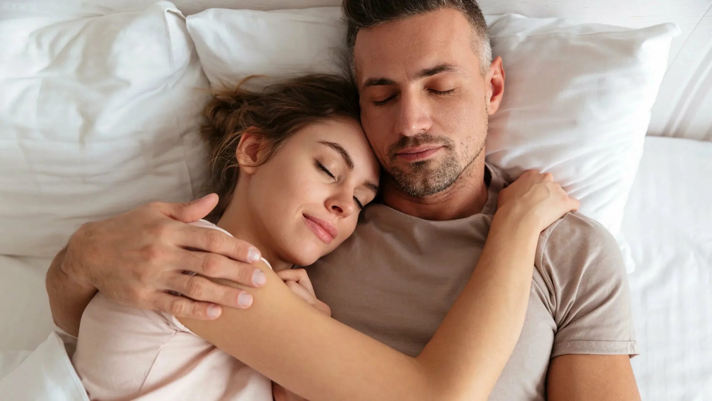 Муж увидел спящую жену. Сон с партнером. Раздельный сон супругов. Довольная жена в постели. Молоденькая пара на кровати.