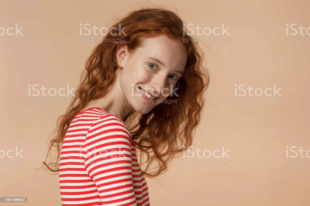 Рыжая молодая девушка улыбается. Рыжая улыбается.