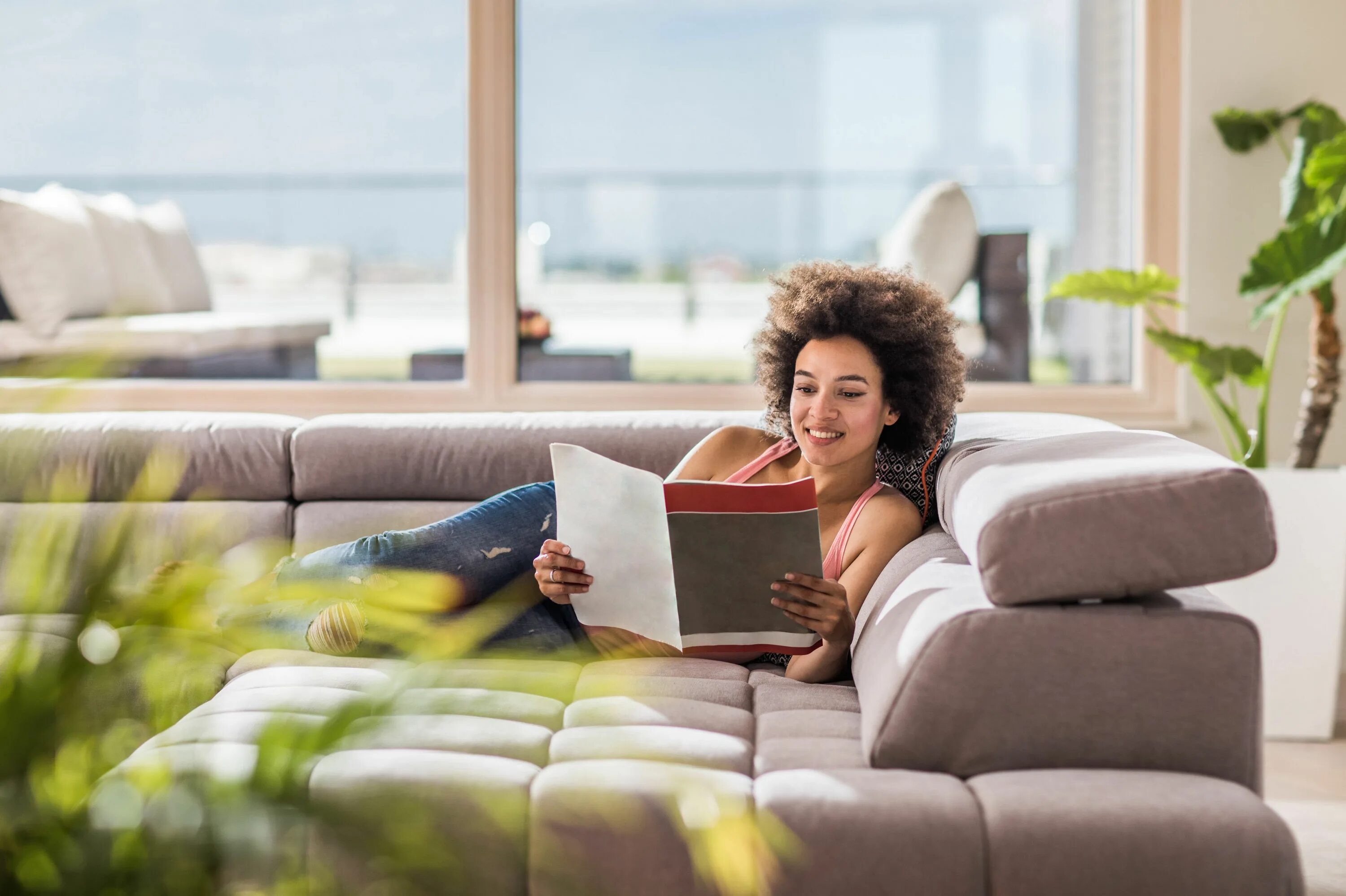 She reads magazines. Человек отдыхает на диване в светлой гостиной. Celebrate on Sofa. Beauty reading on Sofa. Home Sofa women.