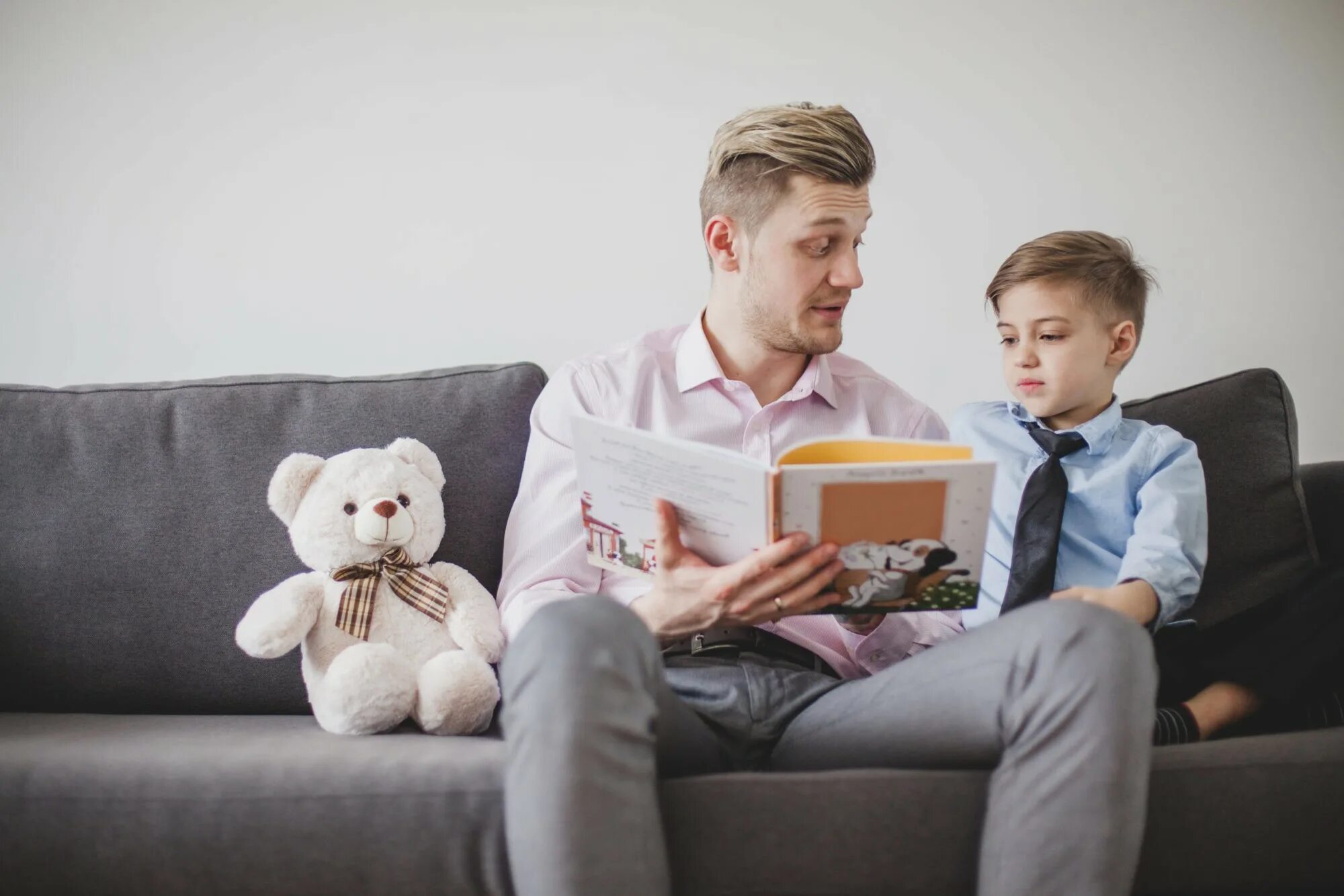 Dad likes playing. Родители читают детям. Книги для детей. Диван для мальчика. Дети с родителями читают книги.