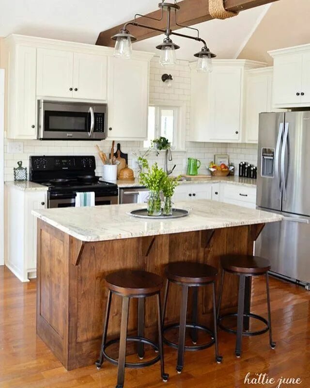There is table in the kitchen. Bar height island dining table storage.
