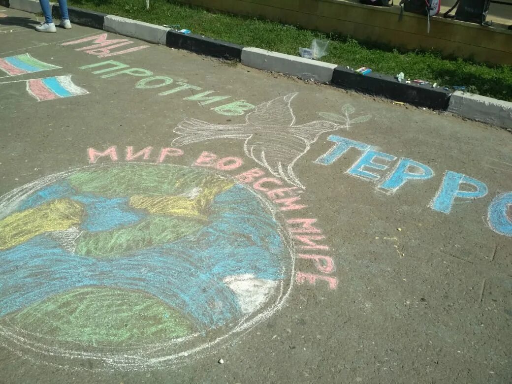 дети рисуют на асфальте. рисование мелками на асфальте. поздравление на асфальте. рекламные надписи на асфальте. слово жителя изумруд на асфальте.