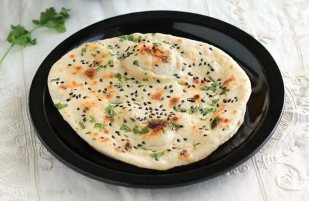 Кульча индийская. Tandoor Naan. Паратха. Лепешка с кунжутом вид сверху. Пряная лепешка