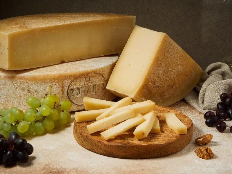 фрукты на деревянной доске. сырная тарелка на деревянной доске. сырная тарелка на деревянной доске. сыр композиция. тарелка для подачи сыра.