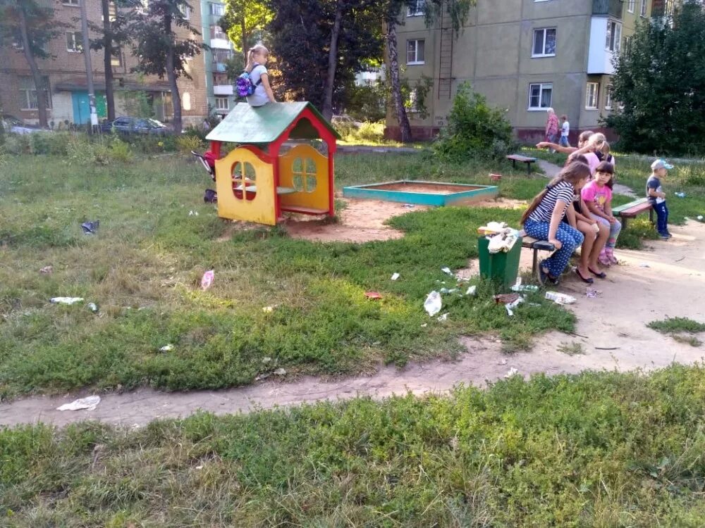 брошенный ребенок во дворе. дети улицы. детская площадка с мусоркой. мусор на детской площадке. брошенные автомобили во дворе многоквартирного дома.