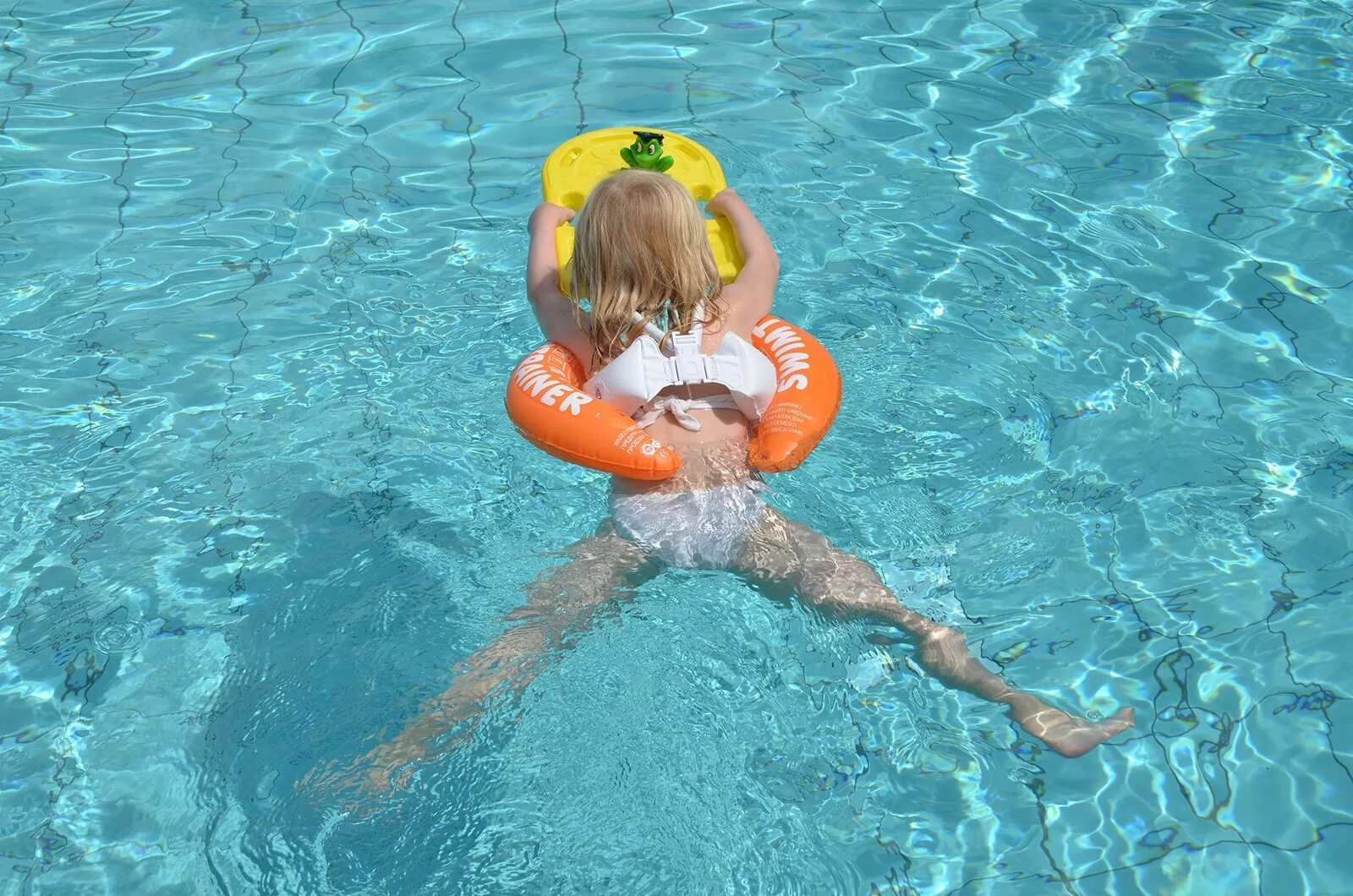 Человек купается в бассейне. Круг Swimtrainer оранжевый. Девочки в бассейне. Оранжевый круг для купания. Дети в бассейне.