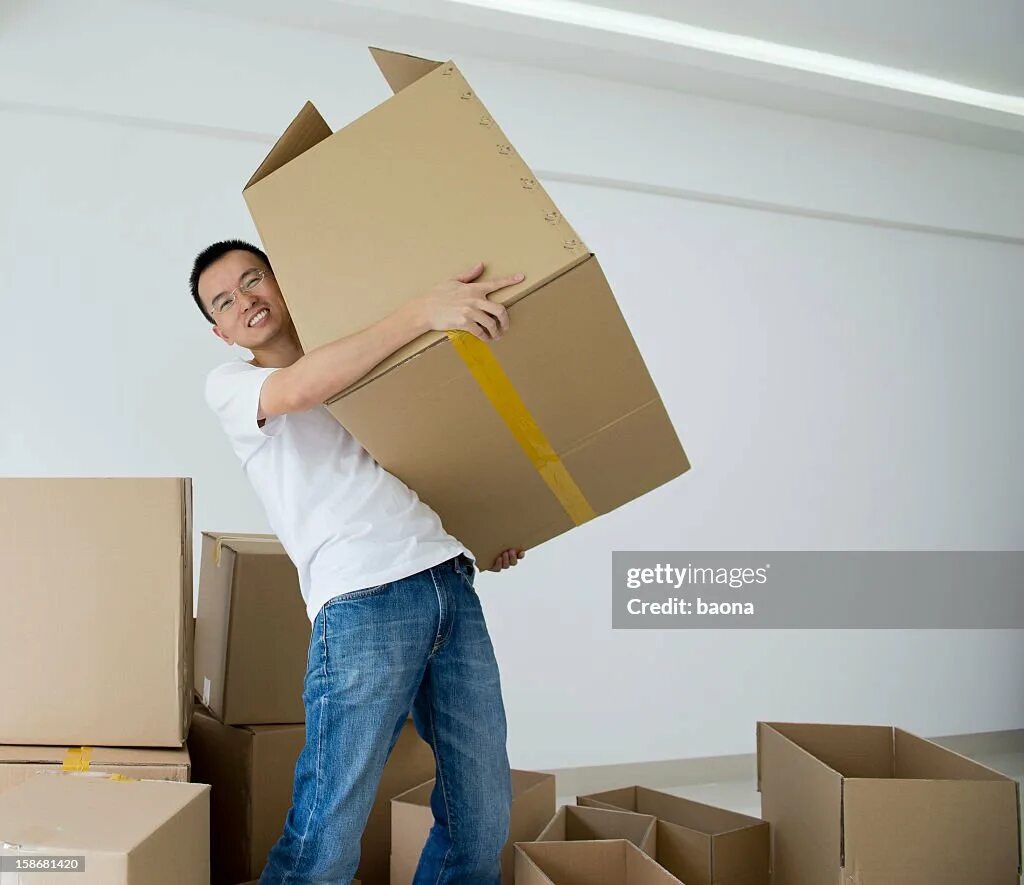 Мужчина с тяжелой коробкой на плече фото. The man carrying the box. Lift box. Heavy box. This box is to lift heavy.
