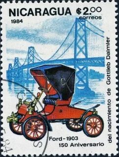 a postage stamp with an old car and bridge in the background 