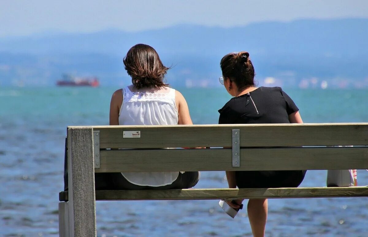 Бесполезный разговор. Двое на скамейке спиной. Фото туристов на пляже. Самый бюджетный курорт в России.