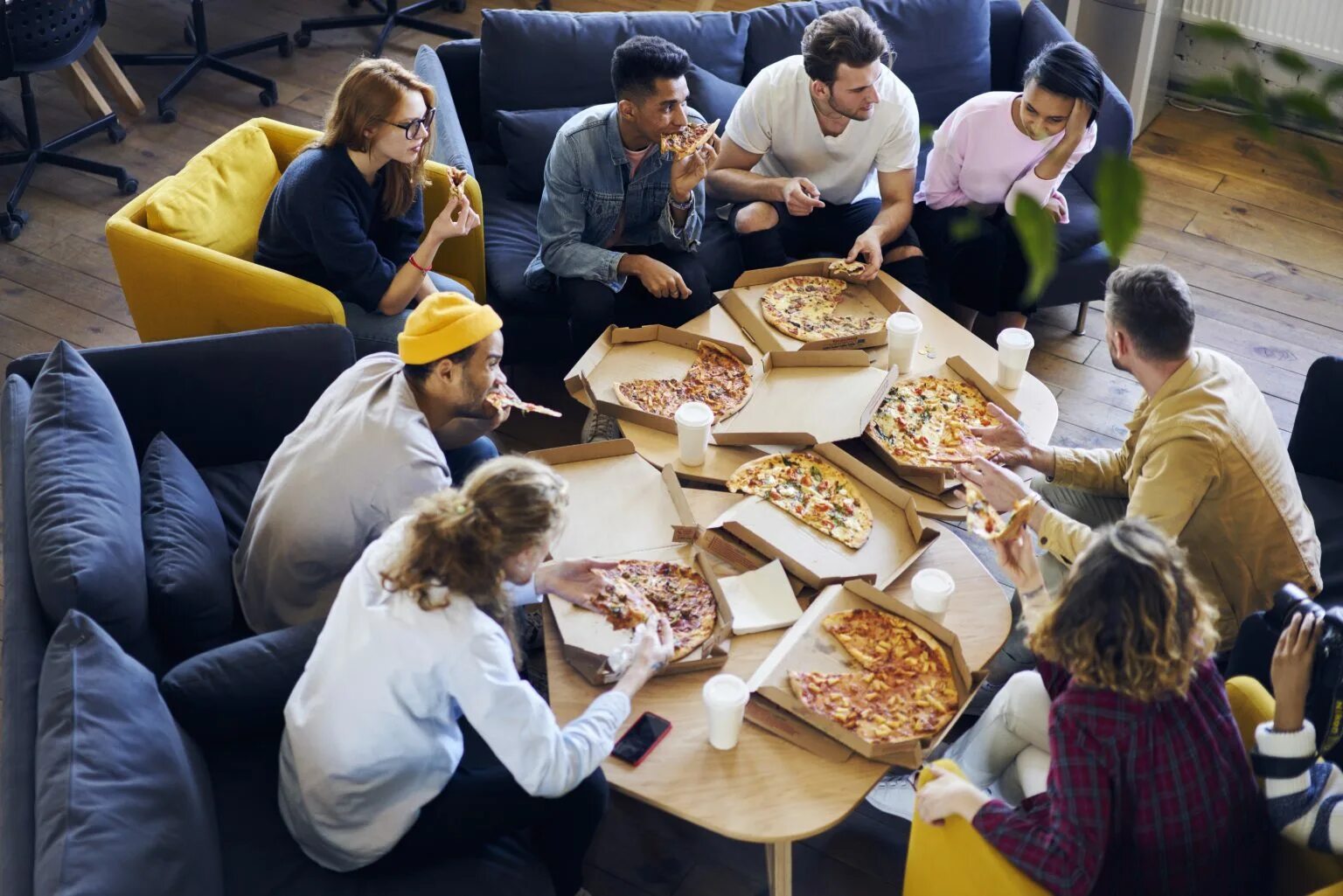 Пицца в офисе. Люди в пиццерии. Люди едят в пиццерии. Едят пиццу в офисе. Где едят люди в доме