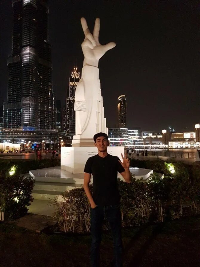 Парень в Дубае. Пальцы статуя Дубай. Скульптура руки в Дубае.