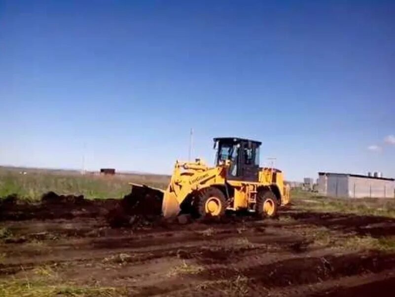 экскаватор-бульдозер jcb 3cx. копка котлована. срезка плодородного слоя грунта. подготовка участка к строительству. срезка растительного слоя грунта бульдозером.