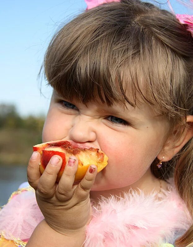 Девочка показала персик. Девочка с персиками. Девочка ест персик. Ребенок ест. Девушка ест персик.