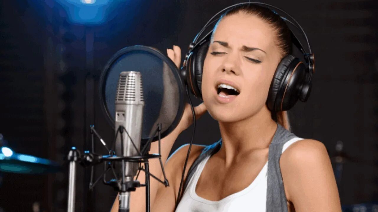 Запись вокала в студии. Девушка поет в студии. Запись в звукозаписывающей студии. Певица в студии звукозаписи.