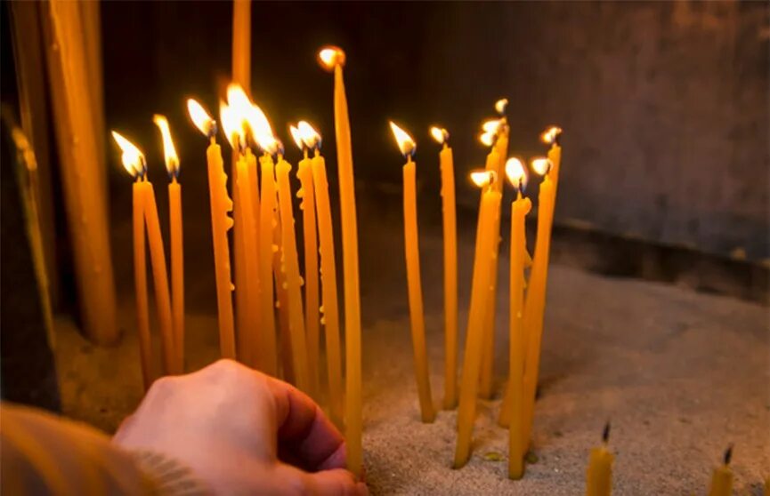 переворачивать свечки. запалить зажигалкой свечу. церковные свечи. перевернутая свеча в церкви. поджигание свечи.
