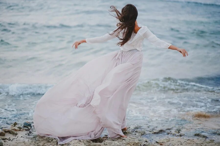 Девушка в длинном белом платье. Фотосессия на море в длинном платье. Развивающееся платье. Девушка в длинном платье на море. Женщина идет по берегу