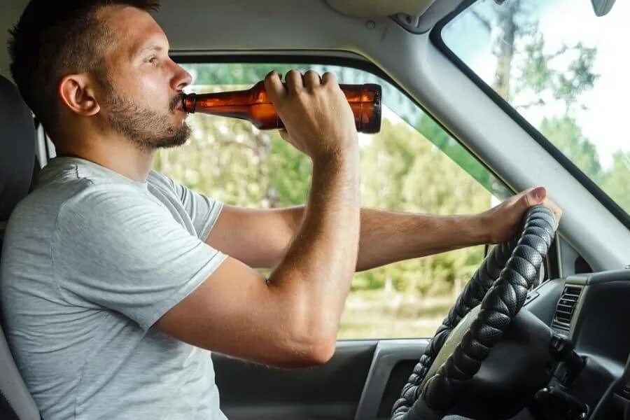 Похмелье за рулем. Пиво за рулем. Пьют в машине. Водитель пьет. Человек пьет за рулем.