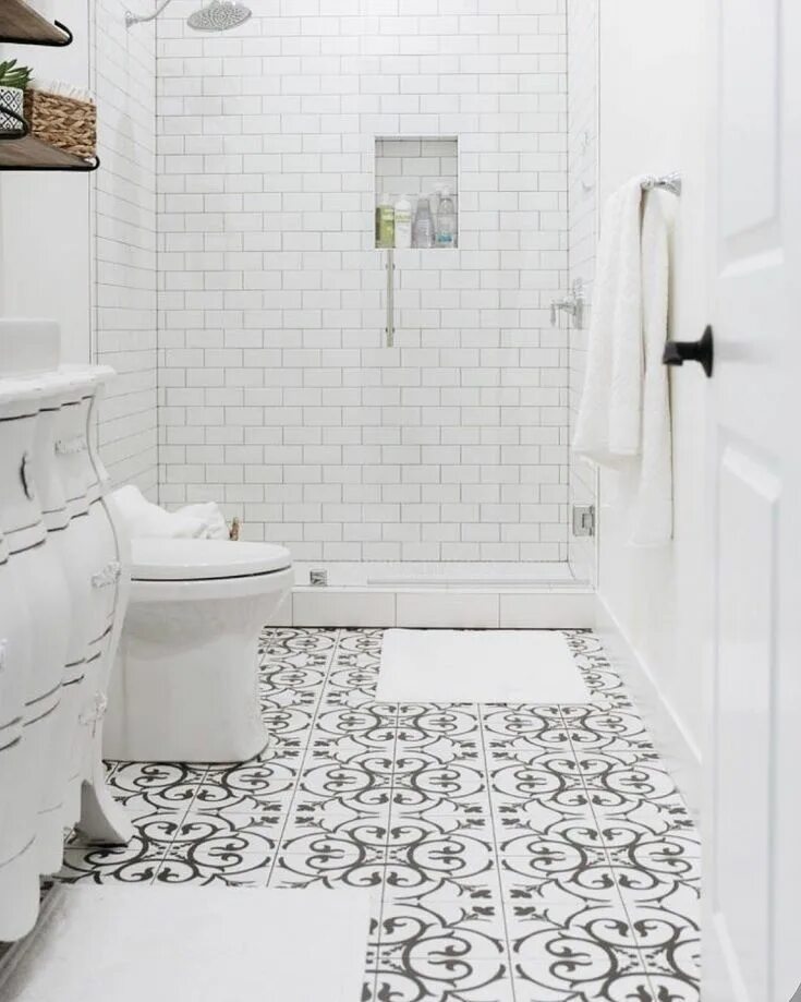 The floor of this bathroom is covered in clean white rectangular tiles mixed wit