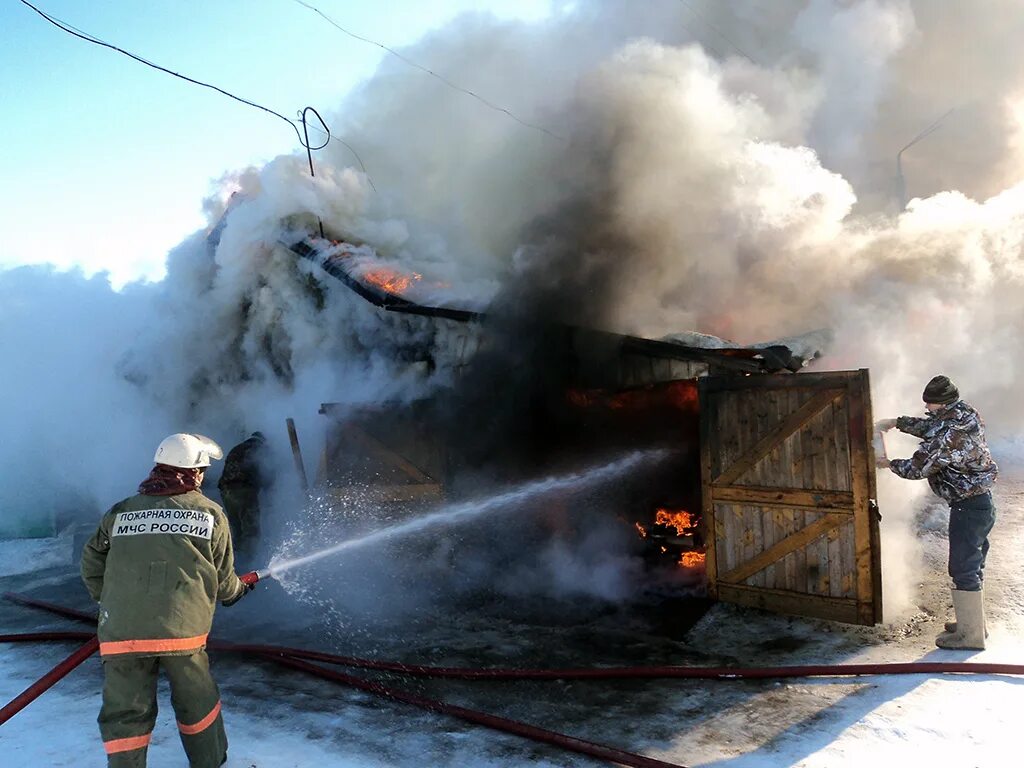 Пожар зимой. Тушение пожара. Тушение пожара зимой. Пожарные тушат деревянный дом.