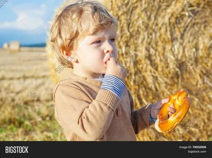 Download high-quality Funny cute little kid boy eating pretzel on late imag...