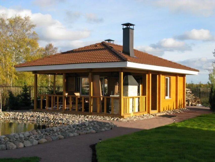 Дом шале из клееного бруса 100кв. Терраса под одной крышей. Баня с террасой и барбекю с односкатной крышей. Терраса под одной крышей. Баня из оцилиндрованного бревна с террасой и барбекю.